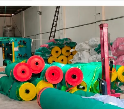 Shade-net rolls in green and other colours on the production floor